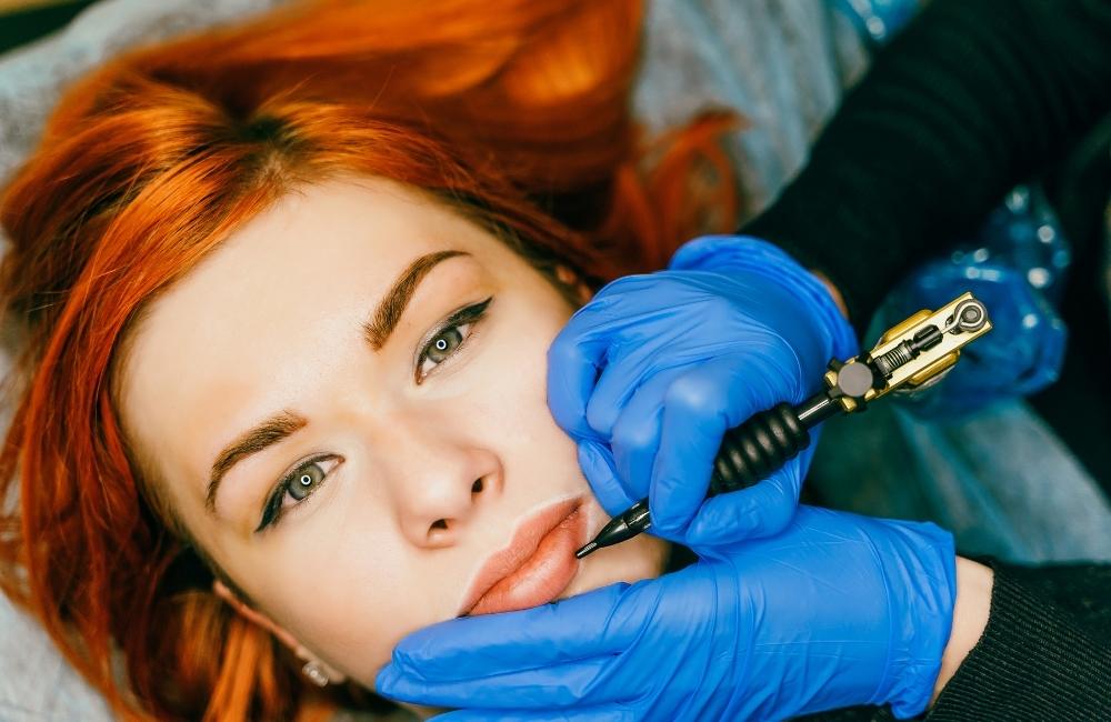woman getting a cosmetic lip tattoo done on her lips