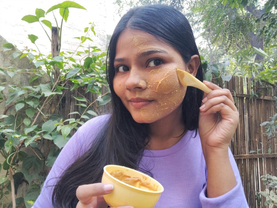 a woman using thanaka powder for her face and skin